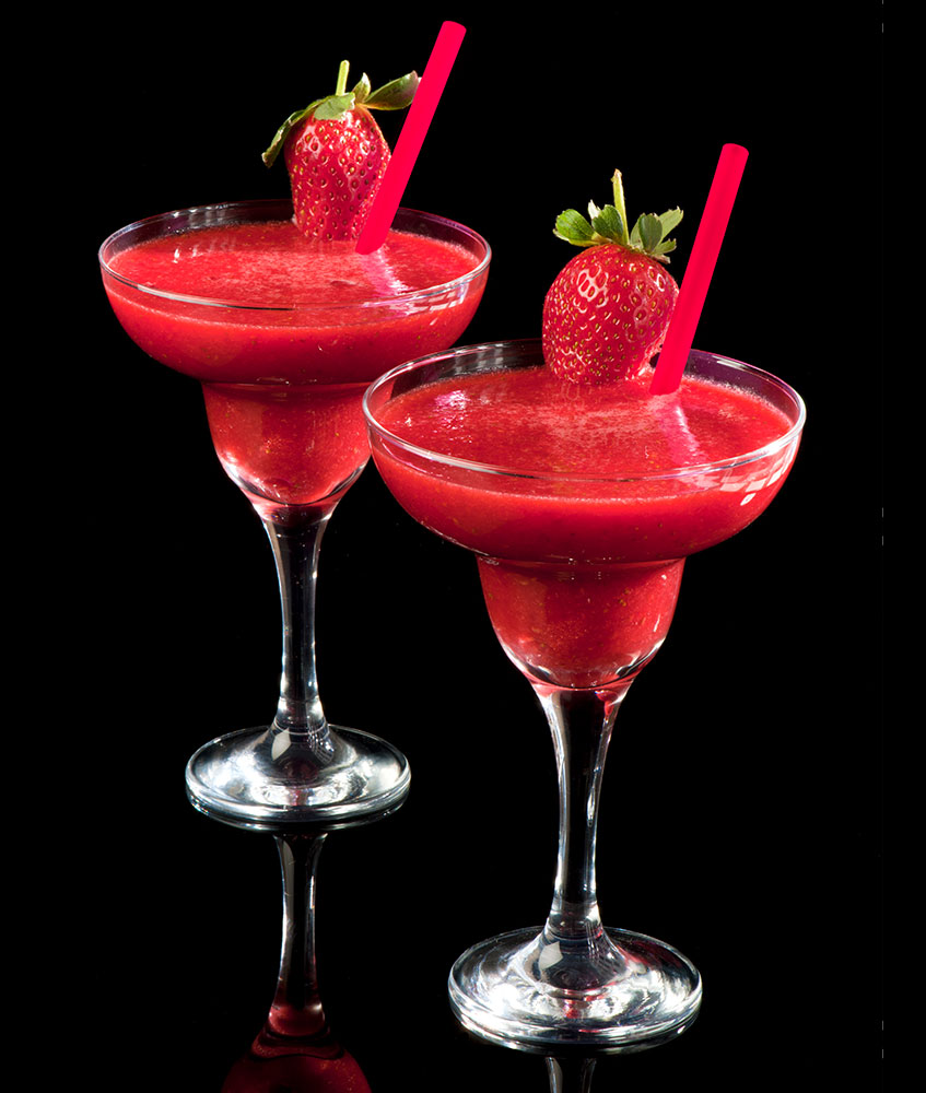two strawberry daiquiris garnished with a strawberry