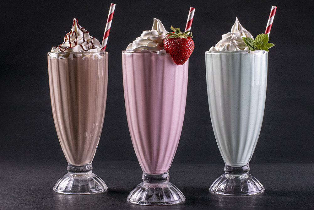a chocolate, strawberry and vanilla milkshake in tall glasses